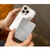 Na zdjęciu widać ręce trzymające smartfon z trzema obiektywami aparatu oraz powerbank z napisem "FIXED" na powierzchni. Powerbank ma gładką, błyszczącą powierzchnię.