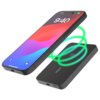 Na zdjęciu widoczny jest czarny powerbank z oznaczeniem "qi" oraz smartfon z wyświetlaczem pokazującym godzinę 9:40. Zielone linie sugerują bezprzewodowe ładowanie między urządzeniami.