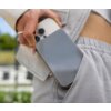 Osoba trzyma telefon i powerbank, który jest częściowo schowany w kieszeni spodni. Na powerbanku widoczne jest logo "FIXED".