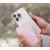 Na zdjęciu widać dwie dłonie trzymające smartfon oraz różowy powerbank z widocznym napisem "FIXED". Powerbank ma gładką powierzchnię i zaokrąglone krawędzie.