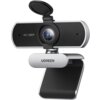 Kamera internetowa z napisem "HD 1080P" na przedniej części obudowy, posiada obiektyw z osłoną oraz uchwyt z logo "UGREEN". Produkt ma nowoczesny design z czarno-srebrnym wykończeniem.