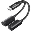 Na zdjęciu znajduje się czarny adapter z logo "UGREEN" na wtyczce USB-C, rozdzielający się na dwa porty: jeden oznaczony symbolem błyskawicy i literami "PD", a drugi symbolem słuchawek. Adapter ma elastyczny, pleciony kabel.