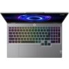 Na zdjęciu widoczny jest otwarty laptop z podświetlaną klawiaturą w kolorach tęczy oraz ekranem wyświetlającym abstrakcyjny, niebiesko-fioletowy wzór. W prawym górnym rogu ekranu znajduje się logo "LOQ".