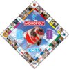 Plansza do gry Monopoly z motywem kotów, z centralnym obrazem kota w czerwonym kostiumie superbohatera na tle nieba z chmurami. Na planszy widoczne są pola z różnymi zdjęciami kotów oraz napisy: "MONOPOLY", "EDYCJA KOTY", "PIESZCZOCHY", "START", "W CHWILI