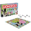 Pudełko gry planszowej "Monopoly Edycja Psy" z kolorowymi zdjęciami psów na okładce oraz plansza do gry z podobnymi motywami. Obok znajdują się metalowe pionki w kształcie kości, miski, buta, obroży i innych akcesoriów.