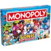 Pudełko gry planszowej z napisem "MONOPOLY" na czerwonym tle oraz "SONIC THE HEDGEHOG" na niebieskim tle, otoczone kolorowymi postaciami z serii Sonic. W lewym górnym rogu widnieje napis "Od zera do milionera", a w dolnym lewym rogu oznaczenie wiekowe "8+