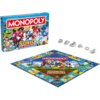 Pudełko gry planszowej "Monopoly Sonic the Hedgehog" z kolorową grafiką postaci z serii Sonic oraz plansza do gry z centralnym obrazkiem przedstawiającym te same postacie. Obok planszy znajdują się metalowe pionki w różnych kształtach, a na pudełku widnie