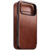 Brązowe etui skórzane z widocznymi przeszyciami i miejscem na aparat, zaprojektowane do telefonu. Etui ma gładką powierzchnię i wycięcia na przyciski boczne.