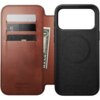 Brązowe skórzane etui z trzema kieszonkami na karty i miejscem na banknoty, z widocznym napisem "NOMAD Horween Leather Co Chicago, IL Est. 1905". Po prawej stronie znajduje się czarna część etui z okrągłym wzorem.