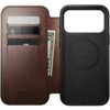 Brązowe etui skórzane z trzema kieszonkami na karty i miejscem na banknoty, obok czarna część z okrągłym wzorem MagSafe. Na etui widoczny jest napis: "NOMAD Horween Leather Co. Chicago, IL Est. 1905".