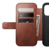 Brązowe skórzane etui z trzema kieszonkami na karty i miejscem na banknoty, z widocznym napisem "NOMAD Horween Leather Co. Chicago, Est. 1905". Po prawej stronie znajduje się miejsce na telefon z okrągłym wzorem.