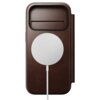 Brązowe etui wykonane z rustykalnej skóry, z okrągłym białym elementem na powierzchni oraz wąskim poziomym otworem w górnej części. Produkt jest przeznaczony do telefonu Apple iPhone 17 Pro.