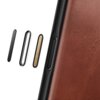 Brązowe etui skórzane z widocznymi przyciskami bocznymi, wykonane z materiału o teksturze skóry. Obok etui znajdują się trzy różne wkładki przycisków w kolorach czarnym, srebrnym i złotym.