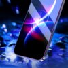 Na zdjęciu widoczny jest smartfon z założoną folią ochronną, na ekranie którego wyświetlają się kolorowe, abstrakcyjne wzory w odcieniach niebieskiego i fioletowego. Tło jest rozmyte, z elementami przypominającymi rozproszone światło.