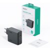 Na zdjęciu znajduje się szara ładowarka sieciowa z trzema portami USB i napisem "140W" oraz opakowanie z napisem "AUKEY Comet Mix 4 140W PD Wall Charger with GaN Technology". Obok leży instrukcja obsługi z widocznym logo "AUKEY".