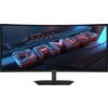 Na zdjęciu widoczny jest zakrzywiony monitor z wyświetlonym na ekranie trójwymiarowym napisem "GAMING" w kolorach niebieskim i czerwonym. Na dolnej ramce monitora znajduje się logo "GIGABYTE".