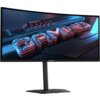 Monitor GIGABYTE z zakrzywionym ekranem wyświetla grafikę z napisem "GAMING" w stylu neonowym. Na obudowie widoczne jest logo "GIGABYTE".