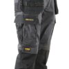 Czarne spodnie robocze z widocznymi kieszeniami i żółtymi przeszyciami, na których znajdują się naszywki z napisami "PROSTRETCH" i "DEWALT GUARANTEED TOUGH". Materiał wygląda na wytrzymały, a kieszenie są zapinane na rzepy.