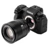 Aparat fotograficzny z widocznym logo "Fujifilm" oraz odłączonym obiektywem, na którym widnieje napis "AF 56mm f/1.2 VCM". Obiektyw jest czarny, z wyraźnie widocznymi pierścieniami regulacyjnymi.