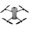 Na zdjęciu widoczny jest szary dron z czterema śmigłami, na którego obudowie znajduje się logo "dji". Śmigła mają pomarańczowe końcówki, a na obudowie drona widoczne są również dwa otwory wentylacyjne.