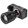 Aparat fotograficzny z widocznym bagnetem do mocowania obiektywu, obok którego znajduje się obiektyw z napisem "AF 56mm f/1.2 VCM". Na korpusie aparatu widoczne są przyciski i pokrętła, a także logo "α".
