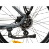 Na zdjęciu widoczny jest fragment tylnego koła roweru z tarczą hamulcową i mechanizmem przerzutki, a na ramie znajduje się napis "TREKKING". W tle widać szprychy oraz część błotnika.