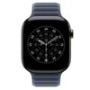 Smartwatch z ciemnoniebieskim paskiem, wyświetlający tarczę zegarka z białymi cyframi i wskazówkami na czarnym tle. Obudowa zegarka jest ciemna, a pasek ma magnetyczne zapięcie.
