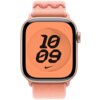 Różowy pasek do zegarka Apple Watch z serii Nike Sport Loop, widoczny na tle tarczy zegarka z pomarańczowym wyświetlaczem, na którym znajduje się czarny napis "10 09" oraz logo Nike. Pasek ma teksturę z widocznym wzorem i zapięciem na rzep.