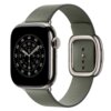 Szarozielony pasek do zegarka Apple Watch z nowoczesnym zapięciem, widoczny na tle zegarka z okrągłą tarczą i oznaczeniami godzinowymi. Pasek ma eleganckie, metalowe wykończenia i kilka otworów do regulacji długości.
