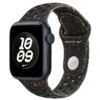 Czarny pasek do zegarka z kolorowymi, nieregularnymi wzorami i perforacjami, z widocznym logo "Nike" oraz napisem "WATCH". Na ekranie zegarka widoczny jest biały, geometryczny wzór z cyframi "10:09".