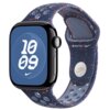 Niebieski pasek do zegarka z otworami i pomarańczowymi akcentami, z widocznym logo "Nike" oraz "WATCH". Na ekranie zegarka widoczny jest biały napis "10 09" na niebieskim tle z białą siatką.