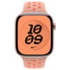 Zegarek z różowym paskiem sportowym, posiada tarczę z pomarańczowym tłem, na której widnieje czarny napis "10:09" oraz logo Nike. Pasek ma okrągłe otwory i kolorowe akcenty.