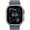 Na zdjęciu widoczny jest smartwatch z granatowym paskiem, na którego ekranie wyświetlane są informacje takie jak godzina 10:09, lokalizacja "WEST MARINA", wysokość 385FT oraz inne wskaźniki nawigacyjne. Obudowa zegarka jest w kolorze srebrnym, a na ekrani