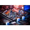 Na zdjęciu znajduje się plansza do gry z figurkami postaci ustawionymi na heksagonalnych polach oraz kilkoma kostkami do gry. W tle widoczny jest fragment pudełka z napisem "PORTAL GAMES Mass Effect".