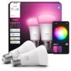 Na zdjęciu znajduje się opakowanie inteligentnych żarówek LED z napisem "PHILIPS hue" oraz dwie żarówki z widocznymi napisami "hue white and color 810". Obok opakowania widoczny jest interfejs aplikacji z kołem kolorów i opcjami regulacji światła.