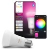 Na zdjęciu znajduje się opakowanie inteligentnej żarówki LED z napisem "PHILIPS hue" oraz symbolem Bluetooth, a także żarówka z napisem "hue white and color 1100". Obok opakowania widoczny jest ekran urządzenia mobilnego z kolorowym kołem do wyboru barwy 