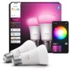 Na zdjęciu znajduje się opakowanie dwóch inteligentnych żarówek LED marki Philips Hue, model 1100, z funkcją Bluetooth i Zigbee, obok którego widoczna jest aplikacja mobilna z kołem kolorów do zmiany barwy światła. Na opakowaniu znajdują się logotypy: "wo