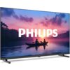 Przedstawiony jest telewizor z widocznym na ekranie obrazem dwóch osób w kajaku na jeziorze o zachodzie słońca, z dużym napisem "PHILIPS" na środku. Obudowa telewizora jest w kolorze ciemnym, a ekran oparty jest na dwóch nóżkach.