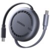 Szary kabel USB-C - USB-C UGREEN L531 o mocy 100W i długości 1 metra jest zwinięty wokół okrągłej obudowy. Na obudowie widoczne jest logo "UGREEN" oraz napis "100W".