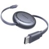 Na zdjęciu znajduje się szary kabel USB-C - USB-C z okrągłym etui, na którym widnieje napis "UGREEN 100W". Kabel jest zwinięty, a na wtyczce również znajduje się napis "UGREEN".