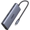 Na zdjęciu znajduje się szary hub USB typu C z kilkoma portami, z widocznym logo "UGREEN 4K 60Hz" na obudowie. Do urządzenia przymocowany jest pleciony kabel zakończony wtykiem USB typu C, również z napisem "UGREEN".