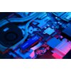 Na zdjęciu widoczna jest płyta główna komputera z zamontowanym dyskiem SSD oznaczonym jako "goodram Core 4TB SSD". Elementy płyty głównej są oświetlone niebieskim i różowym światłem, co tworzy kontrastowy efekt wizualny.