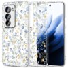 Przezroczyste etui na telefon z wzorem drobnych, niebieskich i żółtych kwiatów oraz zielonych liści. Etui jest dopasowane do modelu telefonu z trzema obiektywami aparatu.