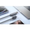 Na zdjęciu widoczny jest szary kabel z końcówkami USB/USB-C oraz USB-C/Lightning, oznaczony napisem "MOCOLL", leżący obok laptopa i tabletu. Kabel ma plecioną strukturę i jest przeznaczony do ładowania lub przesyłania danych.