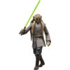 Na zdjęciu znajduje się figurka przedstawiająca postać z serii Star Wars, ubrana w brązowy strój z długimi rękawami i trzymająca zielony miecz świetlny. Figurka ma charakterystyczne cechy twarzy i głowy, które są szczegółowo odwzorowane.