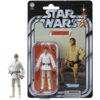 Opakowanie zawiera figurkę postaci w białym stroju z brązowym paskiem, umieszczoną na tle pomarańczowego wnętrza, z napisem "Luke Skywalker" oraz logo "Star Wars" i "Kenner". Obok znajduje się zdjęcie tej samej postaci w plenerze, a na dole widnieje ostrz