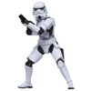 Na zdjęciu znajduje się figurka szturmowca z serii Star Wars, ubrana w biały pancerz z czarnymi elementami, trzymająca broń w pozycji bojowej. Tło jest jednolite i jasne.