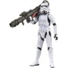 Na zdjęciu znajduje się figurka szturmowca z serii Star Wars The Vintage Collection, trzymająca duży czarny blaster na ramieniu. Figurka ma biały pancerz z czarnymi detalami i charakterystyczny hełm szturmowca.