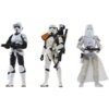 Trzy figurki szturmowców z serii Star Wars The Vintage Collection, każda w białym pancerzu z różnymi detalami i akcesoriami, takimi jak hełmy i broń. Figurka pośrodku ma pomarańczowy naramiennik i plecak z rurką.