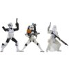 Na zdjęciu znajdują się trzy figurki przedstawiające postacie w białych zbrojach z serii Star Wars, każda z nich trzyma broń i ma różne detale, takie jak hełmy i akcesoria. Figurka pośrodku ma plecak z cylindrycznymi elementami i pomarańczową naramiennik.
